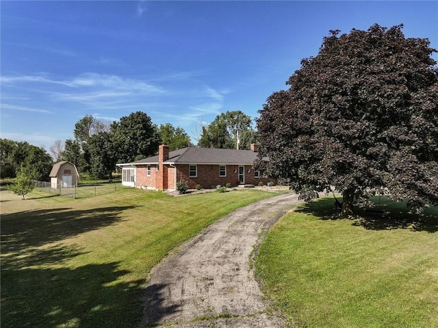 34065 W 135th St, Olathe, KS 66061 - view of front facade featuring a chimney, brick siding, and a storage shed