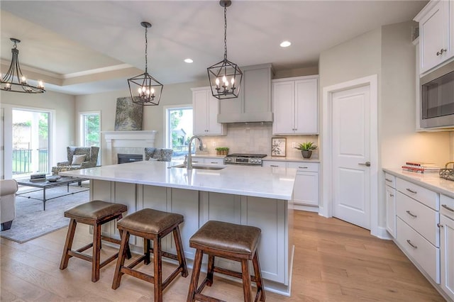 24110 W 95th St, Lenexa, KS 66227 - kitchen featuring stainless steel appliances, open floor plan, light wood-style flooring, a kitchen bar, and backsplash
