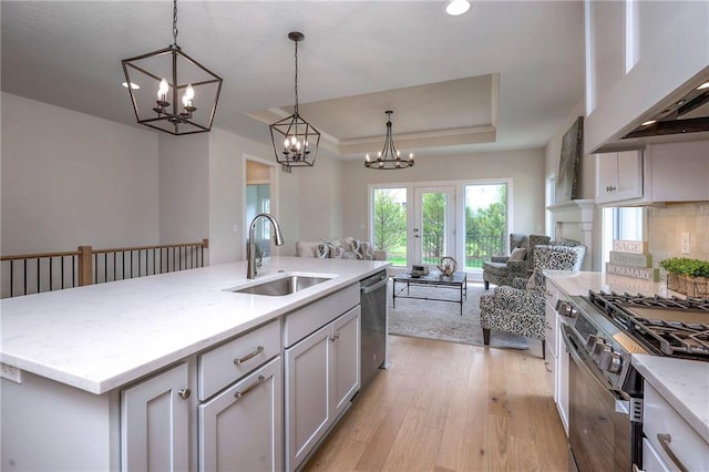 24110 W 95th St, Lenexa, KS 66227 - kitchen featuring open floor plan, a tray ceiling, a chandelier, light wood-style flooring, and exhaust hood