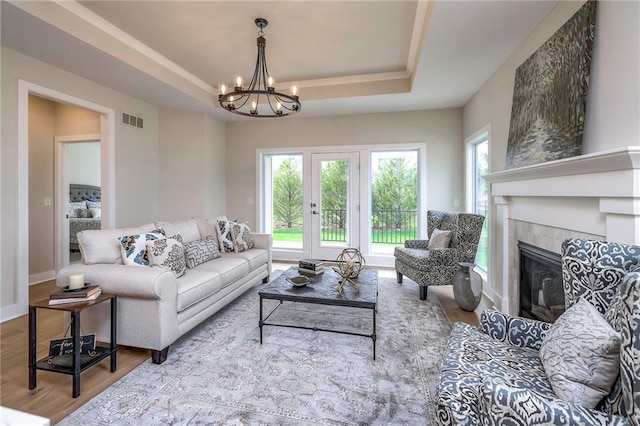 24110 W 95th St, Lenexa, KS 66227 - living room with a chandelier, a tray ceiling, healthy amount of natural light, and wood finished floors