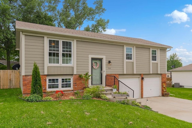 709 S 9th St, Louisburg, KS 66053 - view of front of house with brick siding, concrete driveway, and a garage