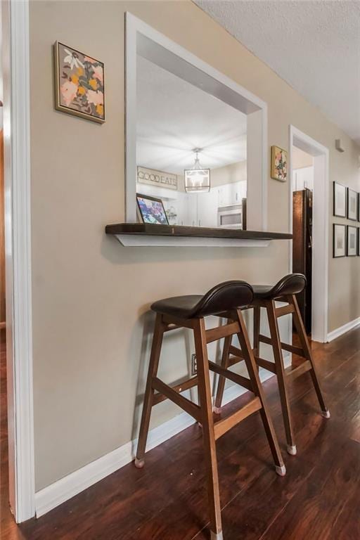 709 S 9th St, Louisburg, KS 66053 - dining area with dark wood-style floors, a chandelier, and a textured ceiling