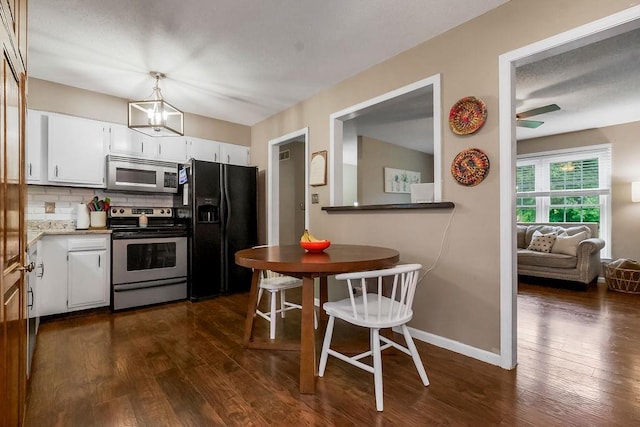 709 S 9th St, Louisburg, KS 66053 - kitchen featuring appliances with stainless steel finishes, dark wood-style flooring, white cabinets, and backsplash