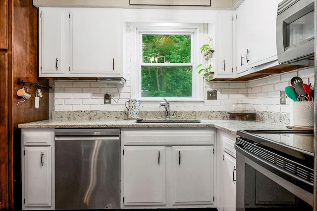 709 S 9th St, Louisburg, KS 66053 - kitchen featuring appliances with stainless steel finishes, white cabinets, backsplash, and light stone counters