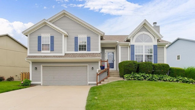 865 W Elizabeth St, Olathe, KS 66061 - view of front facade featuring a front yard, driveway, an attached garage, and a chimney