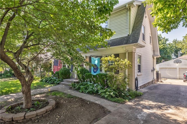 11 W 70th St, Kansas City, MO 64113 - view of front of house with an outbuilding, a garage, and a shingled roof