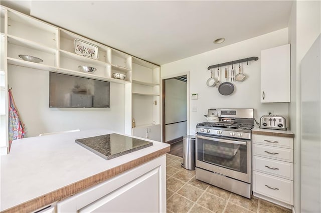 11 W 70th St, Kansas City, MO 64113 - kitchen with gas range, open shelves, white cabinetry, and light tile patterned floors