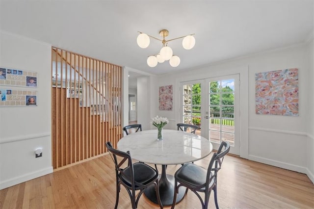 8315 Lee Blvd, Leawood, KS 66206 - dining space featuring light wood-style floors, french doors, a chandelier, and crown molding
