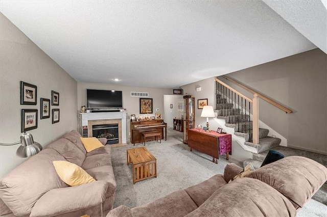 3568 NE Austin Dr, Lees Summit, MO 64064 - carpeted living room featuring stairs, a textured ceiling, and a tiled fireplace