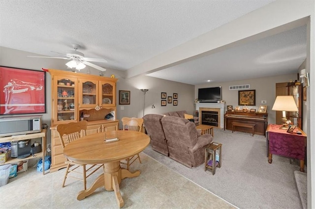 3568 NE Austin Dr, Lees Summit, MO 64064 - dining room featuring a fireplace, a textured ceiling, and a ceiling fan