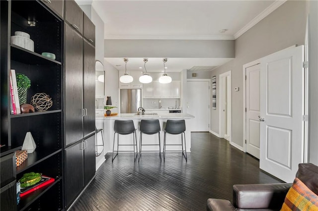 4545 Wornall Rd Unit Le4, Kansas City, MO 64111 - kitchen with a peninsula, light countertops, a kitchen breakfast bar, crown molding, and dark wood-style floors