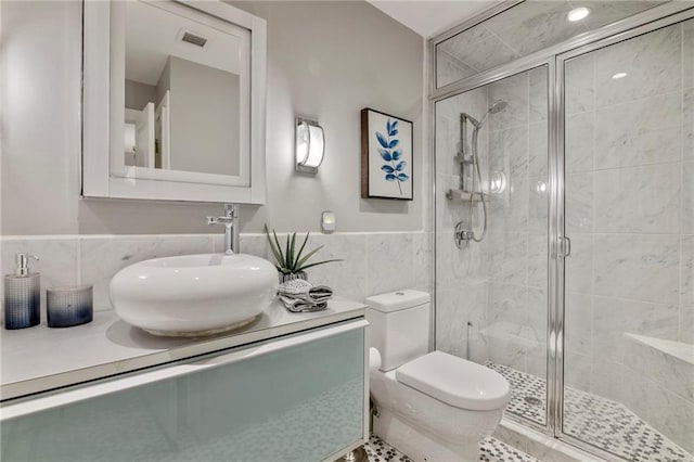4545 Wornall Rd Unit Le4, Kansas City, MO 64111 - bathroom featuring tile walls, vanity, a stall shower, and a wainscoted wall