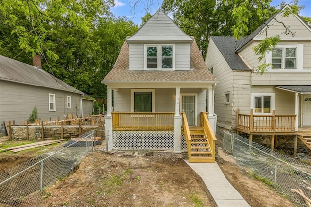 410 Kensington Ave, Kansas City, MO 64124 - view of front of house with stairs, a porch, a shingled roof, and a fenced backyard