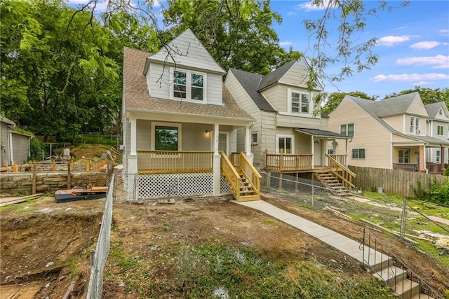 410 Kensington Ave, Kansas City, MO 64124 - view of front of house featuring stairs, a vegetable garden, a shingled roof, a porch, and a deck