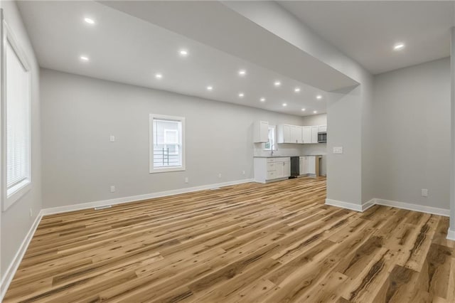410 Kensington Ave, Kansas City, MO 64124 - unfurnished living room with recessed lighting and light wood-type flooring
