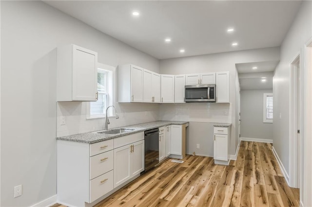 410 Kensington Ave, Kansas City, MO 64124 - kitchen with black dishwasher, stainless steel microwave, backsplash, white cabinets, and recessed lighting