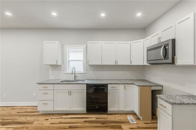 410 Kensington Ave, Kansas City, MO 64124 - kitchen featuring stainless steel microwave, dishwasher, light stone countertops, light wood-style flooring, and recessed lighting