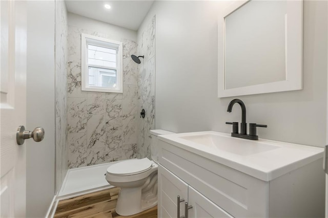 410 Kensington Ave, Kansas City, MO 64124 - full bathroom featuring vanity, a marble finish shower, and wood finished floors