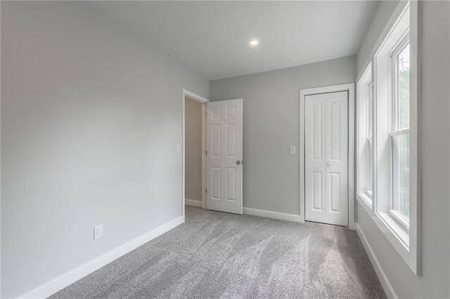 410 Kensington Ave, Kansas City, MO 64124 - unfurnished bedroom with multiple windows, carpet floors, a closet, and recessed lighting