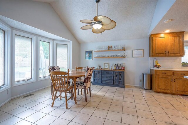 11325 W 54th St, Shawnee, KS 66203 - dining area featuring lofted ceiling, a ceiling fan, a textured ceiling, and light tile patterned floors