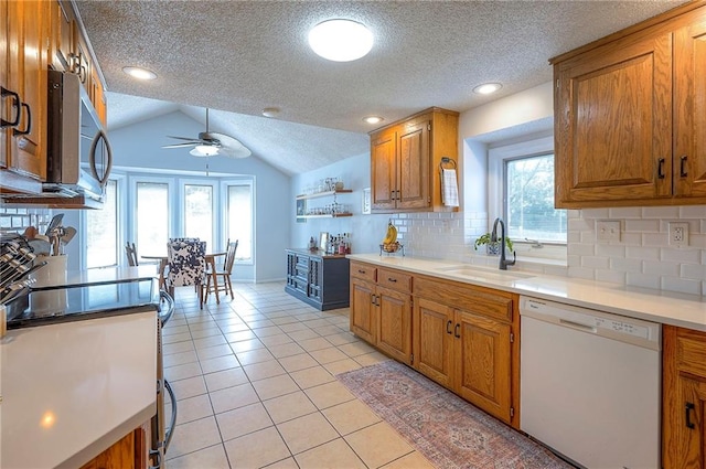 11325 W 54th St, Shawnee, KS 66203 - kitchen featuring white dishwasher, stainless steel microwave, brown cabinetry, a textured ceiling, and vaulted ceiling