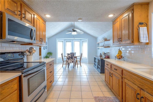 11325 W 54th St, Shawnee, KS 66203 - kitchen featuring appliances with stainless steel finishes, a ceiling fan, a textured ceiling, lofted ceiling, and light countertops