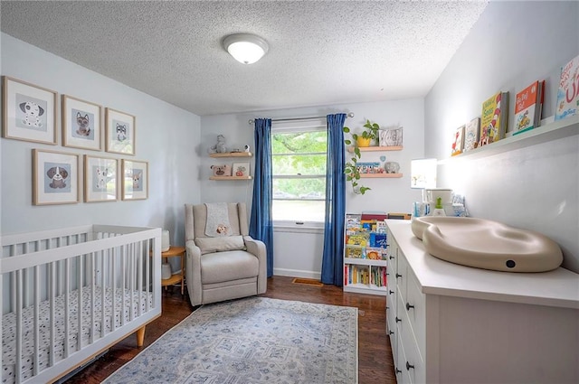11325 W 54th St, Shawnee, KS 66203 - bedroom featuring a nursery area, a textured ceiling, and dark wood-type flooring