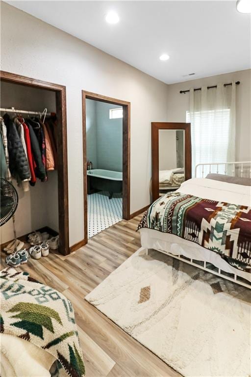 501 NW 101st Rd, Warrensburg, MO 64093 - bedroom with light wood-style flooring, a closet, a walk in closet, ensuite bath, and recessed lighting