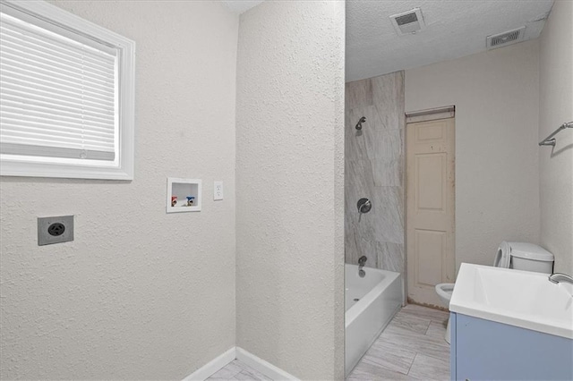 1646 Bennington Ave, Kansas City, MO 64126 - bathroom with vanity, a textured wall, and washtub / shower combination