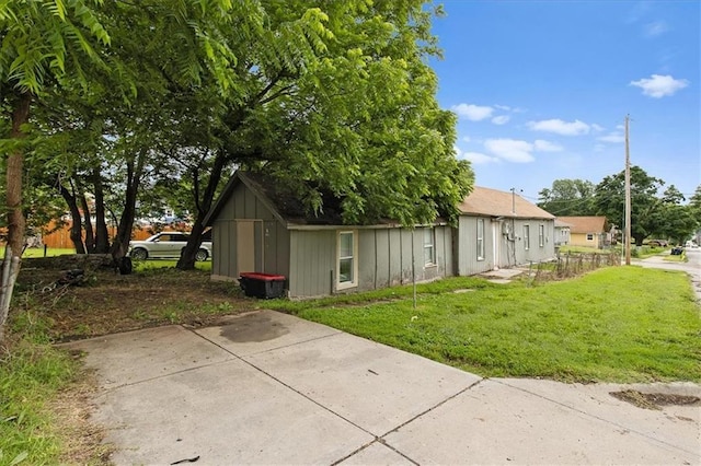 1646 Bennington Ave, Kansas City, MO 64126 - view of side of home featuring a lawn and board and batten siding