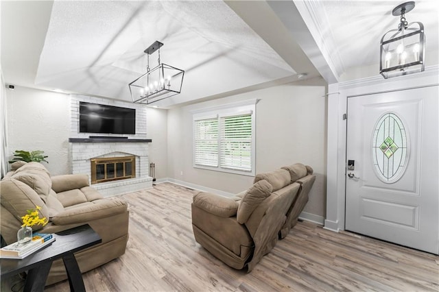 3005 Elmira Ct, Independence, MO 64057 - living area with wood finished floors, a fireplace, a textured ceiling, and a chandelier