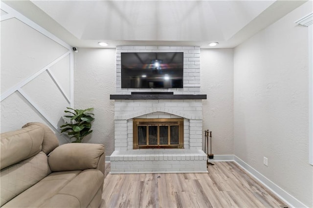 3005 Elmira Ct, Independence, MO 64057 - living area featuring wood finished floors, a fireplace, a textured wall, and recessed lighting