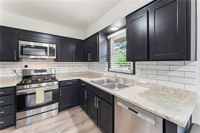3005 Elmira Ct, Independence, MO 64057 - kitchen with appliances with stainless steel finishes, light countertops, light wood-type flooring, backsplash, and dark cabinets