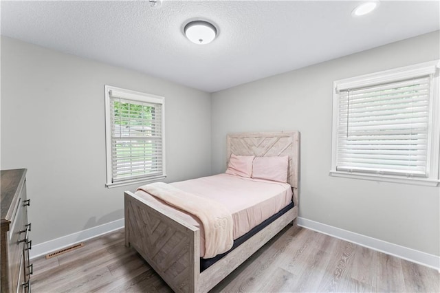 3005 Elmira Ct, Independence, MO 64057 - bedroom featuring light wood-type flooring and a textured ceiling