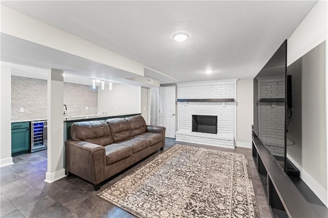3005 Elmira Ct, Independence, MO 64057 - living room featuring beverage cooler, a brick fireplace, bar with sink, and a textured ceiling