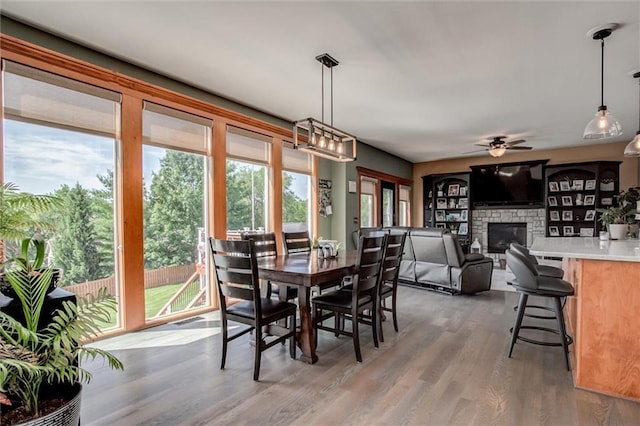 3401 NE 153rd Ter, Smithville, MO 64089 - dining area with a ceiling fan, wood finished floors, and a fireplace