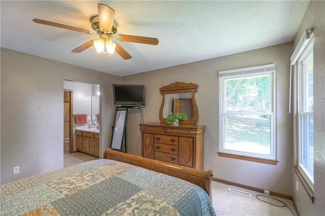 1705 N Jones Ct, Independence, MO 64056 - bedroom with light carpet, a textured ceiling, ensuite bathroom, and a ceiling fan
