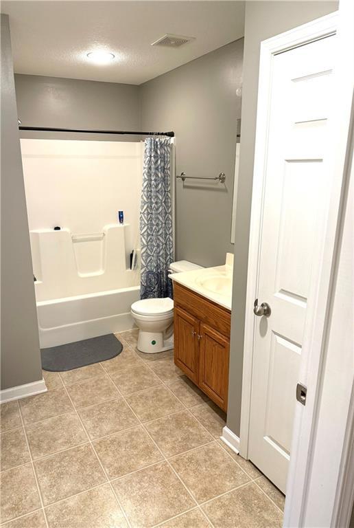 1242 Cypress Ct, Warrensburg, MO 64093 - bathroom featuring vanity, shower / bathtub combination with curtain, and tile patterned flooring