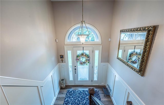 5118 SW Pelican Pt, Lees Summit, MO 64082 - entrance foyer featuring a decorative wall, a towering ceiling, a wainscoted wall, and wood finished floors