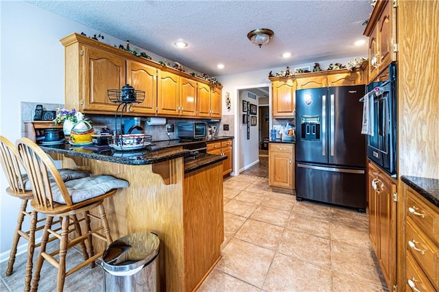 5118 SW Pelican Pt, Lees Summit, MO 64082 - kitchen featuring refrigerator with ice dispenser, a peninsula, brown cabinetry, a breakfast bar area, and backsplash