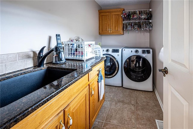 5118 SW Pelican Pt, Lees Summit, MO 64082 - washroom featuring independent washer and dryer, cabinet space, and tile patterned flooring
