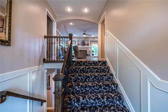 5118 SW Pelican Pt, Lees Summit, MO 64082 - stairs featuring a decorative wall, a ceiling fan, recessed lighting, wainscoting, and carpet flooring