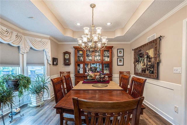 5118 SW Pelican Pt, Lees Summit, MO 64082 - dining area featuring wood finished floors, a chandelier, a raised ceiling, wainscoting, and ornamental molding