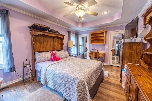 5118 SW Pelican Pt, Lees Summit, MO 64082 - bedroom featuring a tray ceiling, wood finished floors, multiple windows, crown molding, and ceiling fan