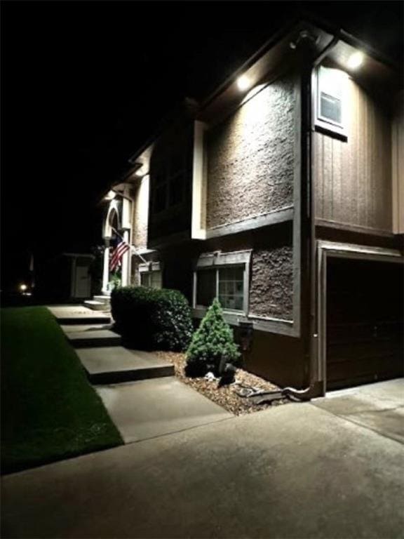 5118 SW Pelican Pt, Lees Summit, MO 64082 - view of property exterior featuring driveway, an attached garage, and stone siding