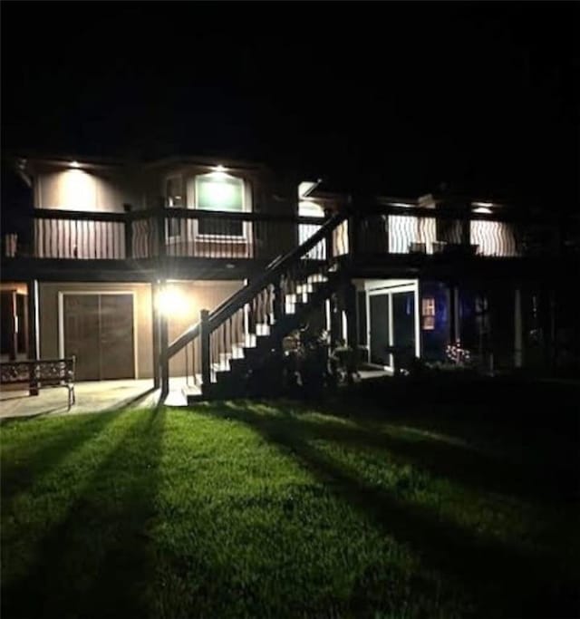 5118 SW Pelican Pt, Lees Summit, MO 64082 - back of house at night featuring stairway, a yard, and an attached garage