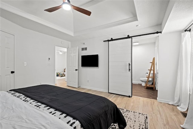 2421 NW Acorn Dr, Blue Springs, MO 64014 - bedroom with a barn door, a raised ceiling, light wood finished floors, ensuite bath, and ornamental molding