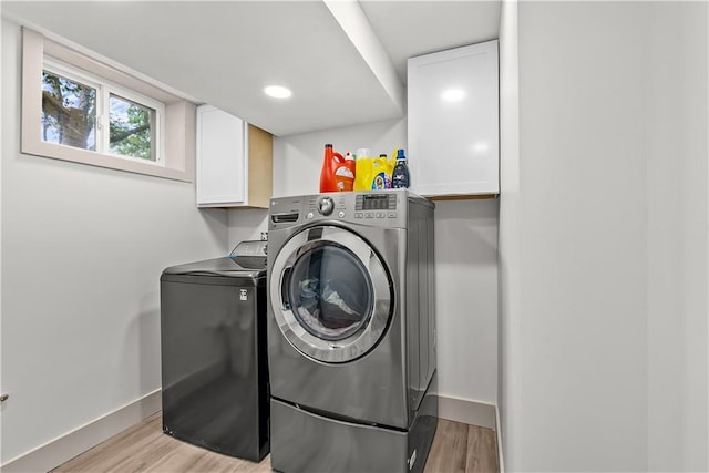 6101 E 107th St, Kansas City, MO 64134 - laundry area with washing machine and dryer, cabinet space, and light wood finished floors