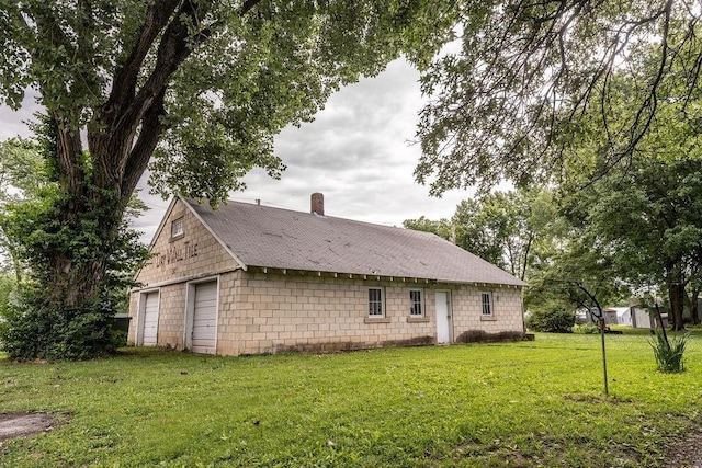 103 N Missouri St, Adrian, MO 64720 - rear view of house with concrete block siding, a garage, a chimney, a yard, and roof with shingles
