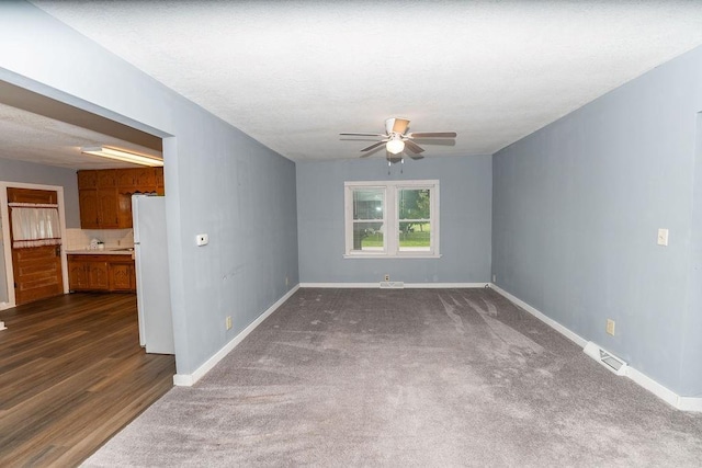 103 N Missouri St, Adrian, MO 64720 - empty room with ceiling fan, dark colored carpet, and dark wood-style flooring